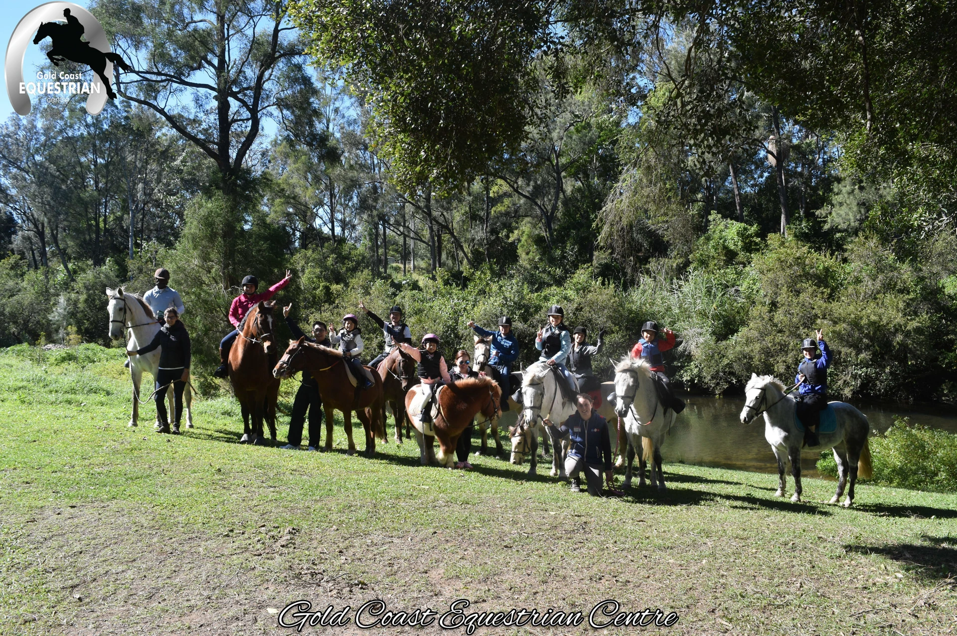 A trail ride group setting out across the paddock