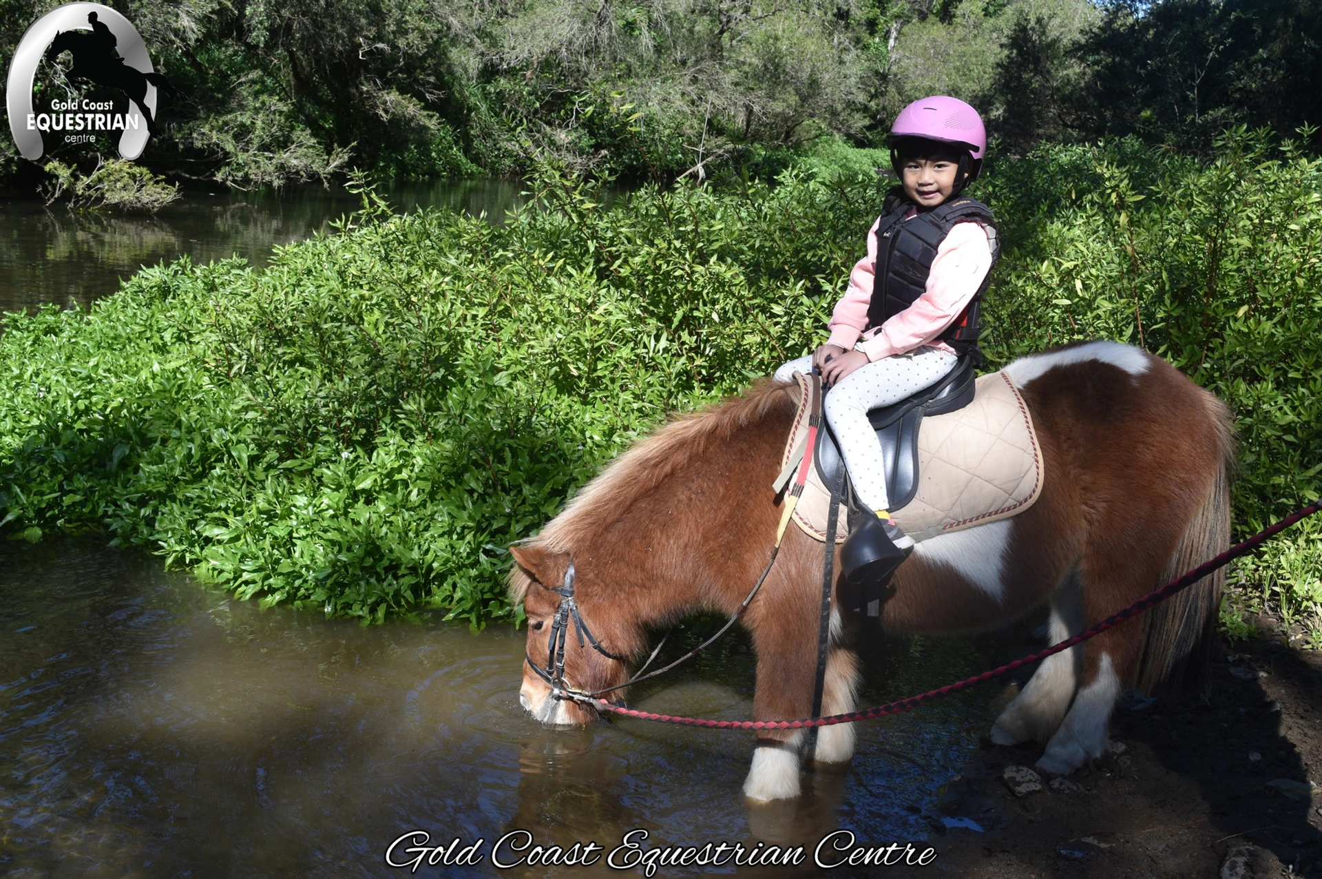 A young rider on a pony in the river