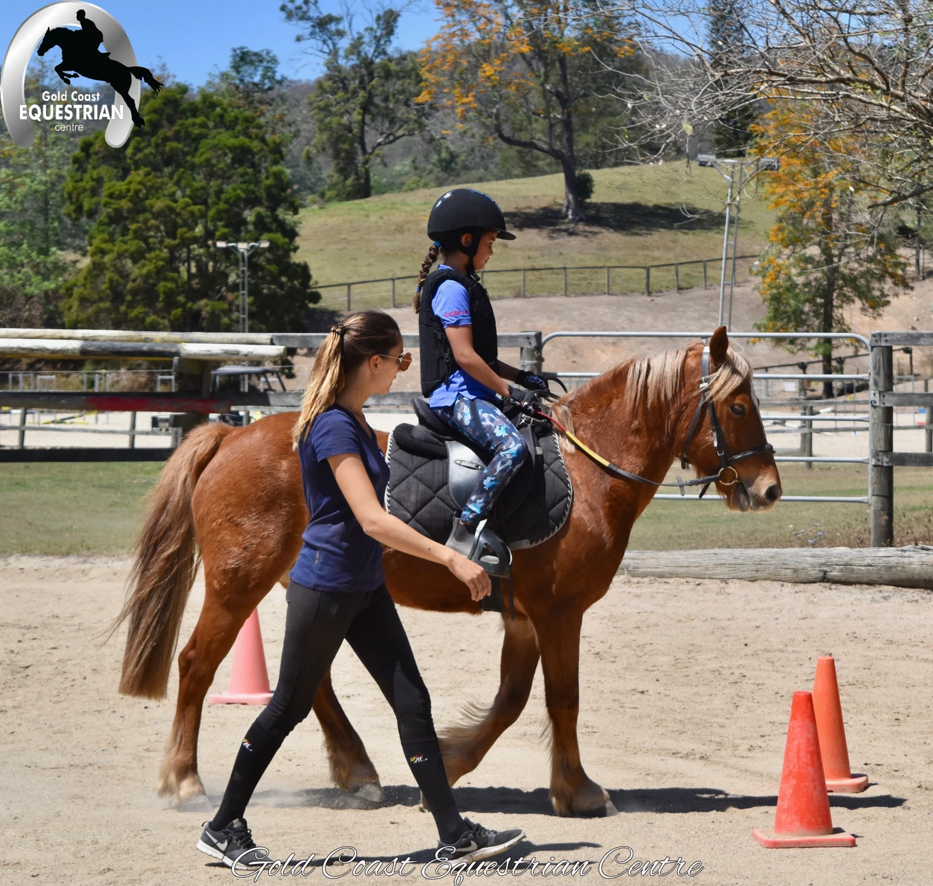 A coach leading a young rider on a chestnut pony