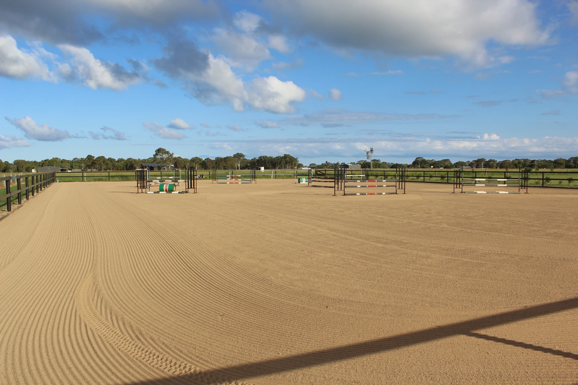 The sand arena and show jumps under a big sky